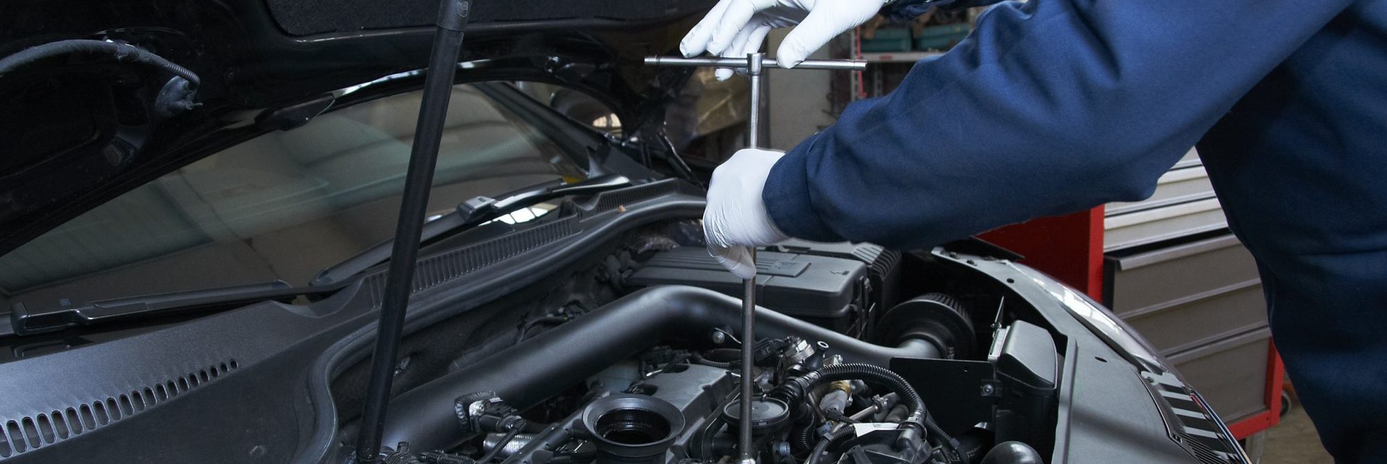 Car repairs with DB Car Doctor in Duxford, near Cambridge. A Mechanic working on an engine.